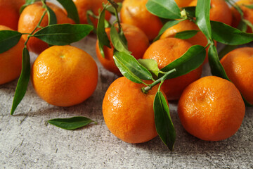Ripe juicy tangerines with green leaves on the table. Fresh fragrant mandarins. 