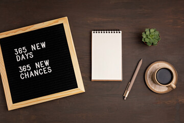 365 new days, 365 new chances. Letter board with motivational quote on dark wooden background with...