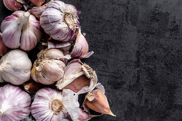 natural food, heads of garlic on a black background. Top view. Copy space.