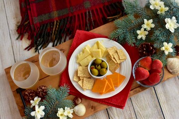 Festive winter Christmas holiday charcuterie board with white wine and seasonal decor ready for sharing