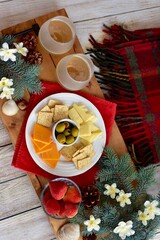 Festive winter Christmas holiday charcuterie board with white wine and seasonal decor ready for sharing