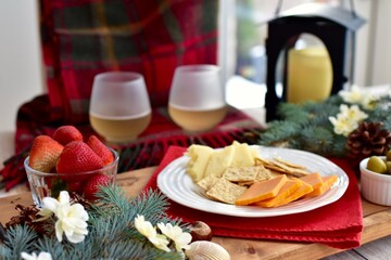 Fototapeta na wymiar Festive winter Christmas holiday charcuterie board with white wine and seasonal decor ready for sharing