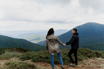 Couple at the peak of the mountain. Lifestyle of travelling people. Love story in the mountains