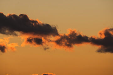 Puffs of clouds over a fiery sunset above New York Harbor