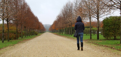 Giovane donna che cammina sul sentiero in campagna in autunno