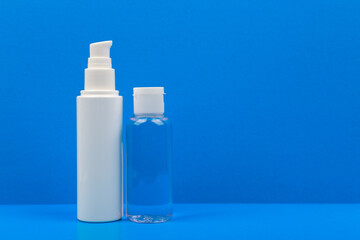 Still life with unbranded face cream and skin lotion on a blue background with a space for text. Concept of daily skin care 