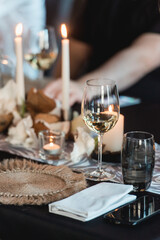 White wine in a glass on the table next to cell phone. Table in a restaurant