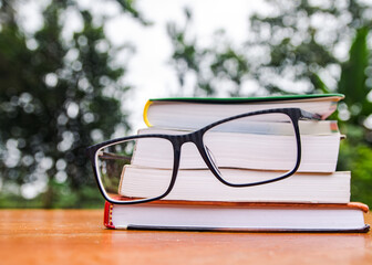 Conjunto de libros de ciencia en una mesa y con unos anteojos 