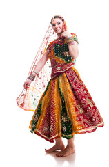 Beautiful young female Bollywood dancer in traditional vivid orange dress with veil