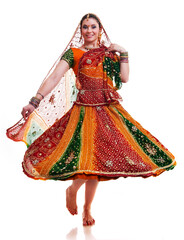 Beautiful young female Bollywood dancer in traditional vivid orange dress with veil