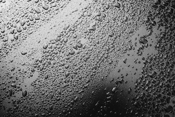 Raindrops on the surface of the car. Black and white photo