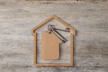 house modell with keys on wooden background