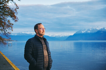 Fototapeta na wymiar Middle age man enjoying promenade next to lake Geneva, Lausanne, Switzerland