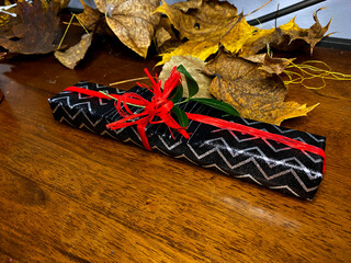 beautifully wrapped gift in a black box with a red ribbon
