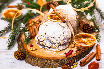 Christmas Holiday Background. Stollen, German Christmas Cake with Dried Fruits and Sliced Almonds Nuts. Selective focus.  