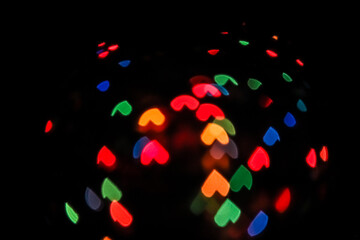 Naklejka na ściany i meble Abstract of colorful background. heart-shaped bokeh light. shimmering blur spot lights on multicolored abstract background. Christmas holiday
