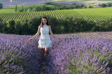 jeune fille en robe blanche au milieu d'un  champ de lavande