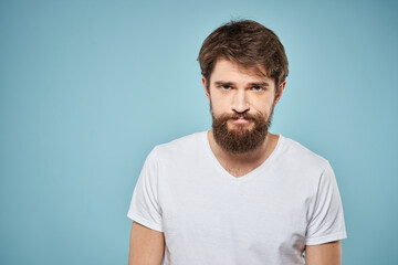 Obraz premium Man in white t-shirt lifestyle studio emotions facial expression blue isolated background