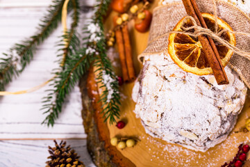 Christmas Holiday Background. Stollen, German Christmas Cake with Dried Fruits and Sliced Almonds Nuts. Selective focus.  