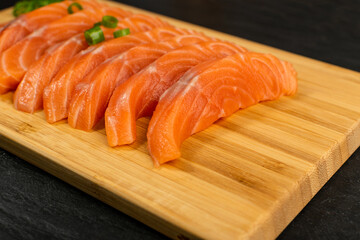 Slices of Raw Salmon Fillet on Black Background