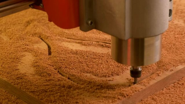 Close up. A wooden cnc machine drills a cutting Board. Automated mechanism. Movement of the drill along the specified route on the computer
