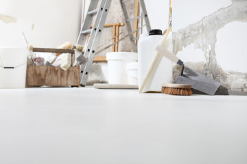 Low angle of indoor shot of construction or building site of home renovation with tools on white...