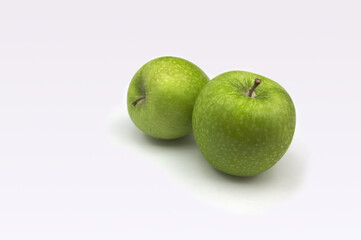 Some greenish golden apples on white