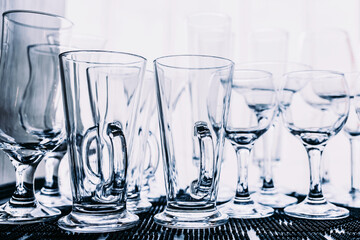 Glasses of different types for drinks close-up on a shelf in a restaurant