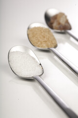 White and brown sugar on spoons