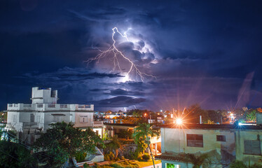 View of lightning at night from the roof of a tonw in Cuba - 393218585