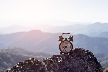 vintage black alarm clock on rock top mountain - Powered by Adobe