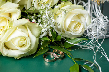 wedding rings, two glasses and a bouquet of white rose