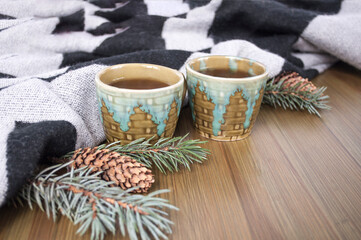 Obraz na płótnie Canvas Two cups of tea, woolen plaid, on a wooden background, winter vacation, horizontal