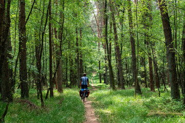 Obraz premium Cyclist on a forest road in summer