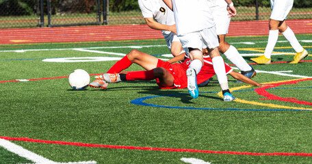 Soccer player slide tackling to get the ball away from competition