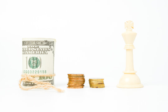 Selective focus of white chess king with fake cash and coin insight. Kingmaker and cash is king concept.