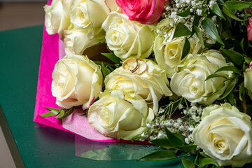 two wedding rings on a white rose bud