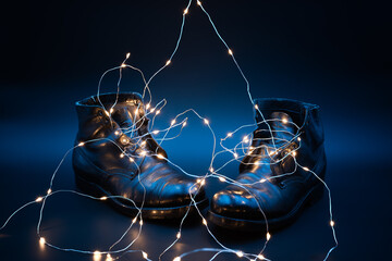 led bulbs laces slip into old black military shoes on a blue background