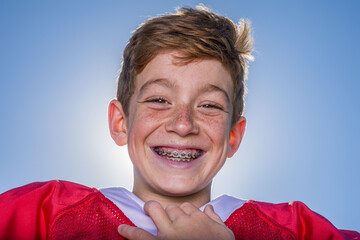 Freckled young football player with braces smiling outside © 3Days2Go Media