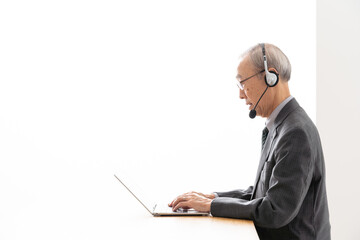 パソコンを使ってビデオチャットをするシニアビジネスマン