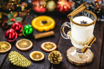 warm homemade Christmas eggnog, based on eggs and alcohol, with dried citrus fruits in the background. Eggnog known as: Auld Man milk, milk and pisco, momo cola, coquito, Crème de Vie or Eierlikör