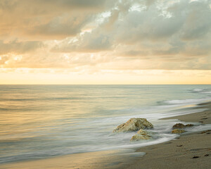 Obraz na płótnie Canvas Long exposure smooth and dreamy beach sunrise with coastal view from South Florida 