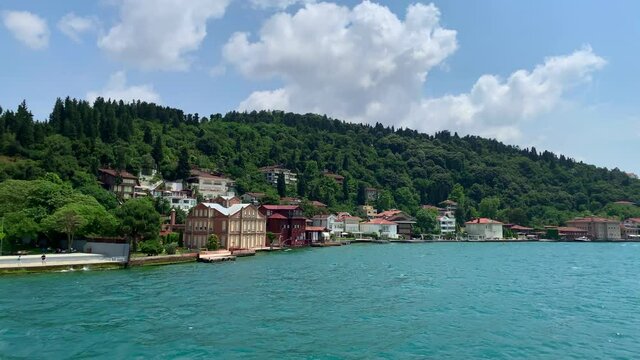 Footage of luxury houses in upscale neighborhood called "Kandilli" by Bosphorus in Istanbul. It is a beautiful summer scene on cloudy summer day. Camera moves forward.