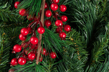 Obraz na płótnie Canvas Fir branches with red fruits, christmas decoration on a tree branches background. Flat lay, top view, copy space