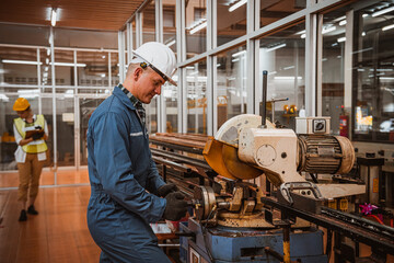 Industry engineering wearing safety uniform control operating computer controlled Lathe grinding machine working in industry factory.