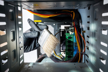 technician worker sweeping dust inside desktop pc. hardware dust cleaning using brush. male person...