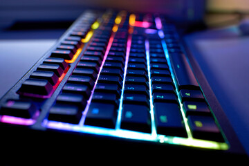 Gaming keyboard with RGB light. Colorful backlit keyboard with blurry background