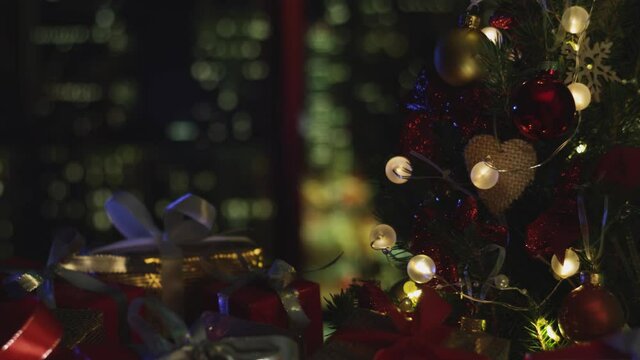 New Years Christmas background. Christmas tree. Flashing lights. Decorations, red gold balls and glowing bulbs on the tree. Warm home mood. Depth of field, soft focus. Red camera 4K