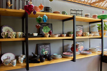 shelf and stand of plates, glasses and ceramic tableware decorated organized and stacked painted green and nature with interior design for the house