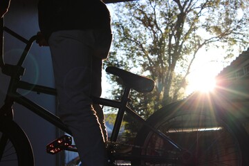 Naklejka na ściany i meble Blurred silhouette of a biker against the sunset